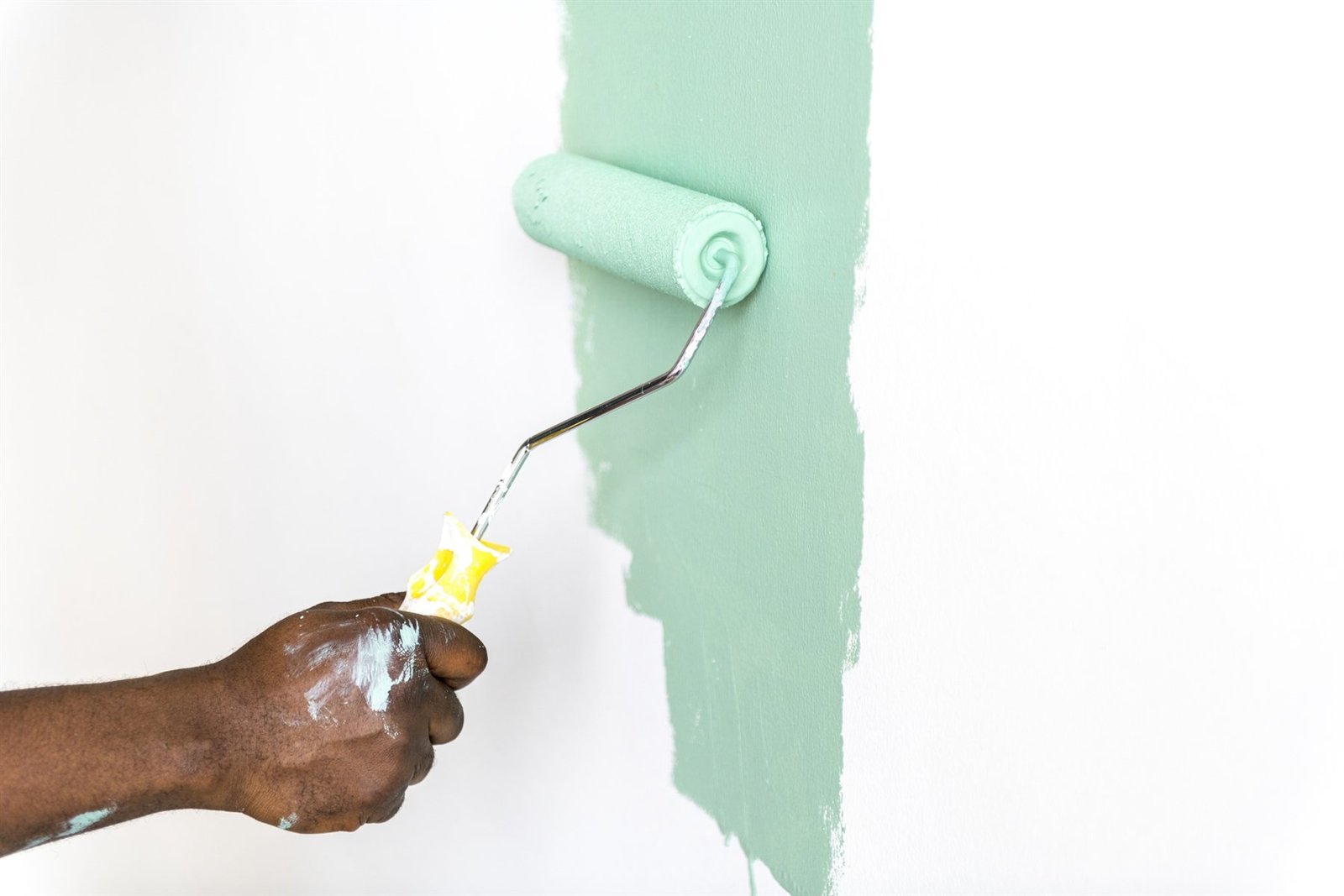 Pessoas renovando uma parede interna com tinta